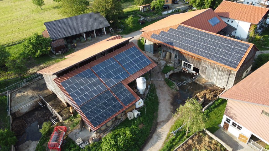drone photo of farm with photovoltaic panels on the roof